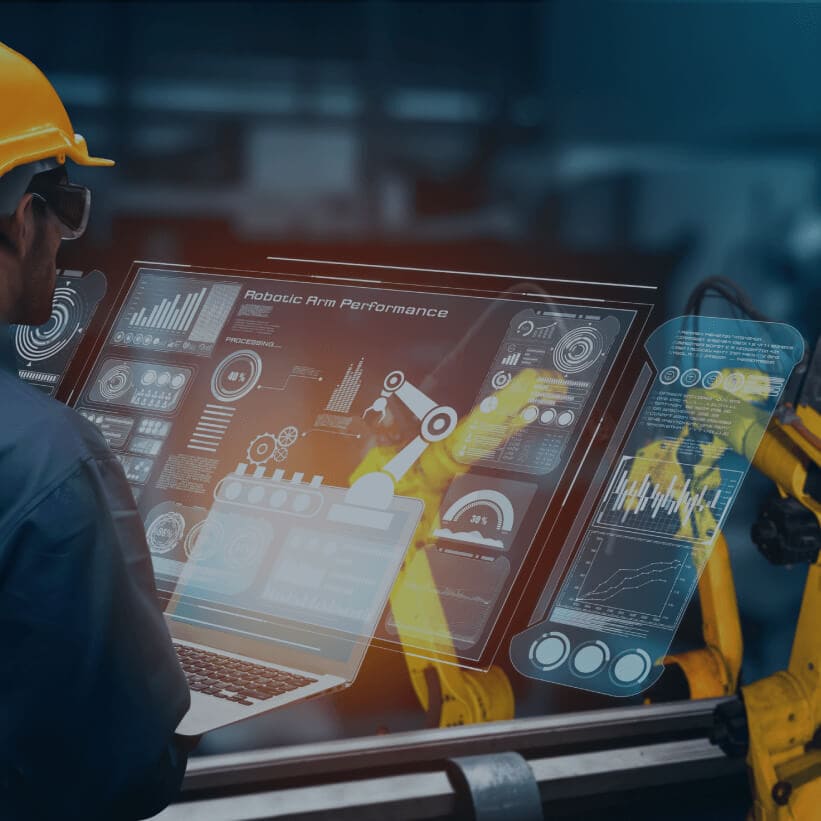 A man wearing a hardhat and helmet is focused on a laptop screen, engaged in work or analysis.